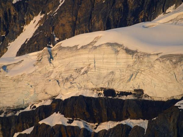 This photo shows the beautiful sight of a giant glacier. This glacier has formed slowly over many years, gradually making its way down a mountain, adding ice and snow with each passing day.