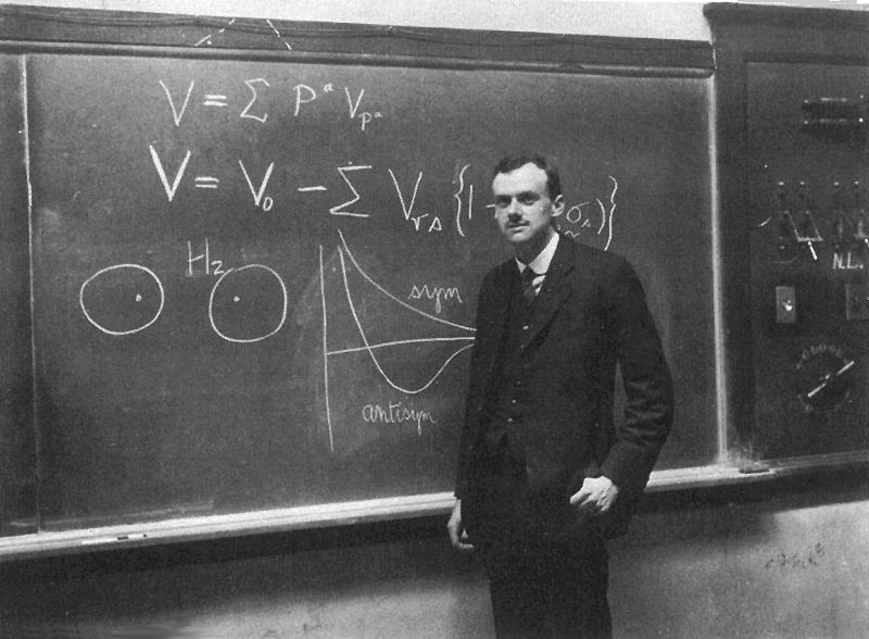This photo shows British theoretical physicist Paul Dirac standing in front of a blackboard. Dirac made many contributions in the early development of quantum mechanics.