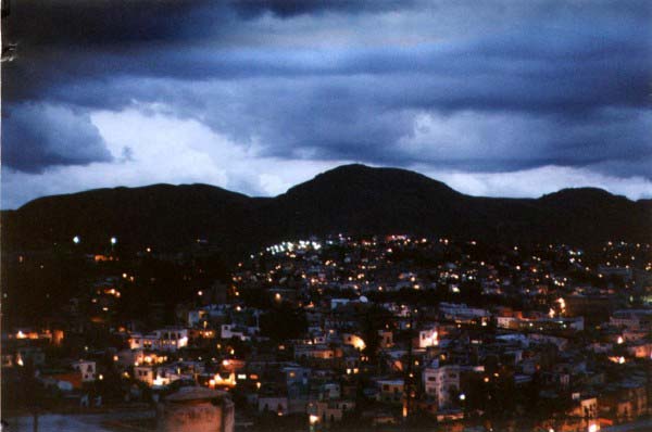 Dark skies hang above a small town late on a stormy day.